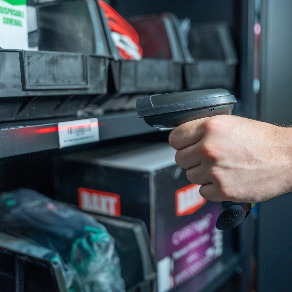 man scanning stock in cupboard